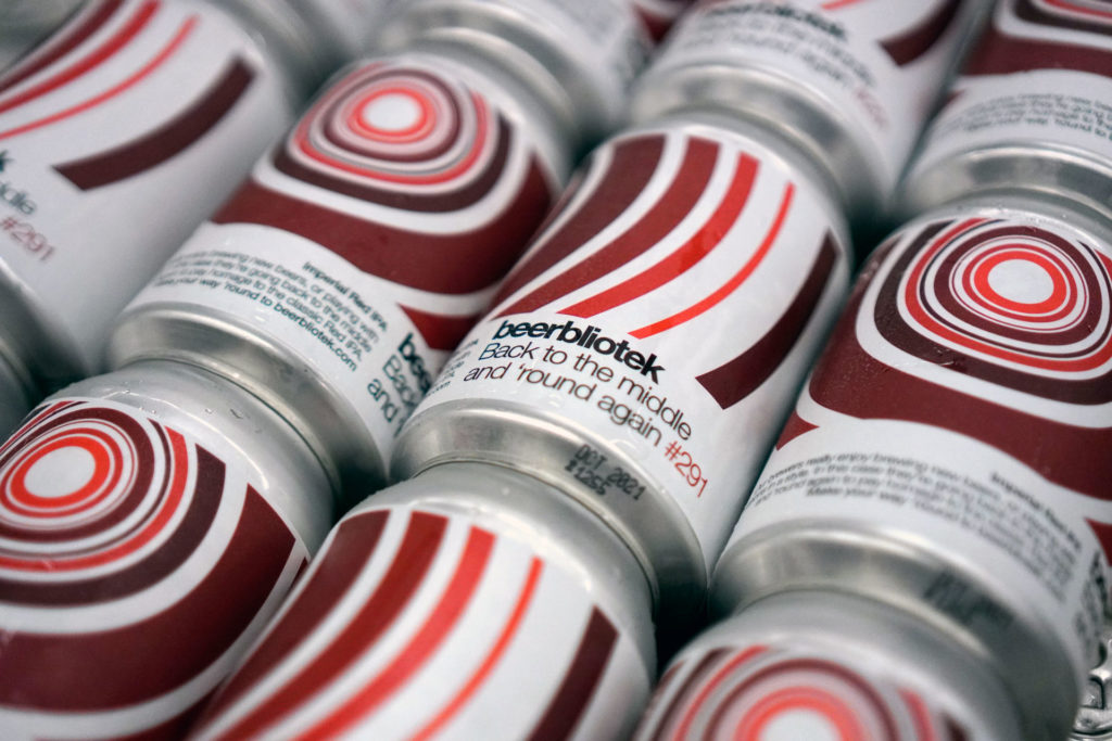 a pattern of cans of Back to the middle and 'round again, an Imperial Red IPA brewed in Gothenburg, by Swedish Craft Brewery Beerbliotek.