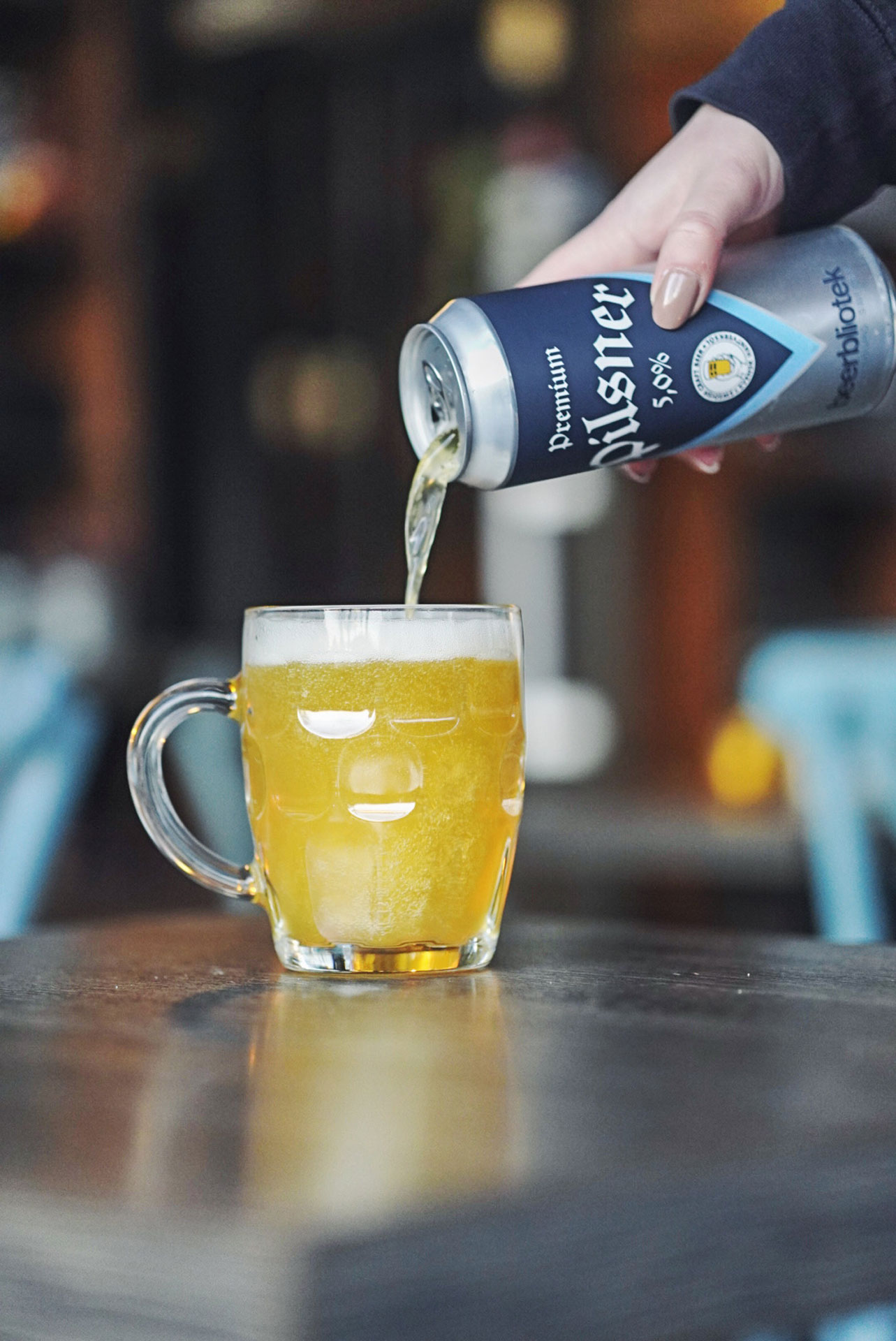 A photo of a can being poured into a glass of Premium Pilsner, a Pilsner, brewed by Swedish Craft Beer brewery, Beerbliotek, in Gothenburg. Premium Pilsner is Beerbliotek's first 500ml Can.